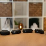 Hot stones rest on a person's back.