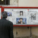 man reading newspaper in bulletin board